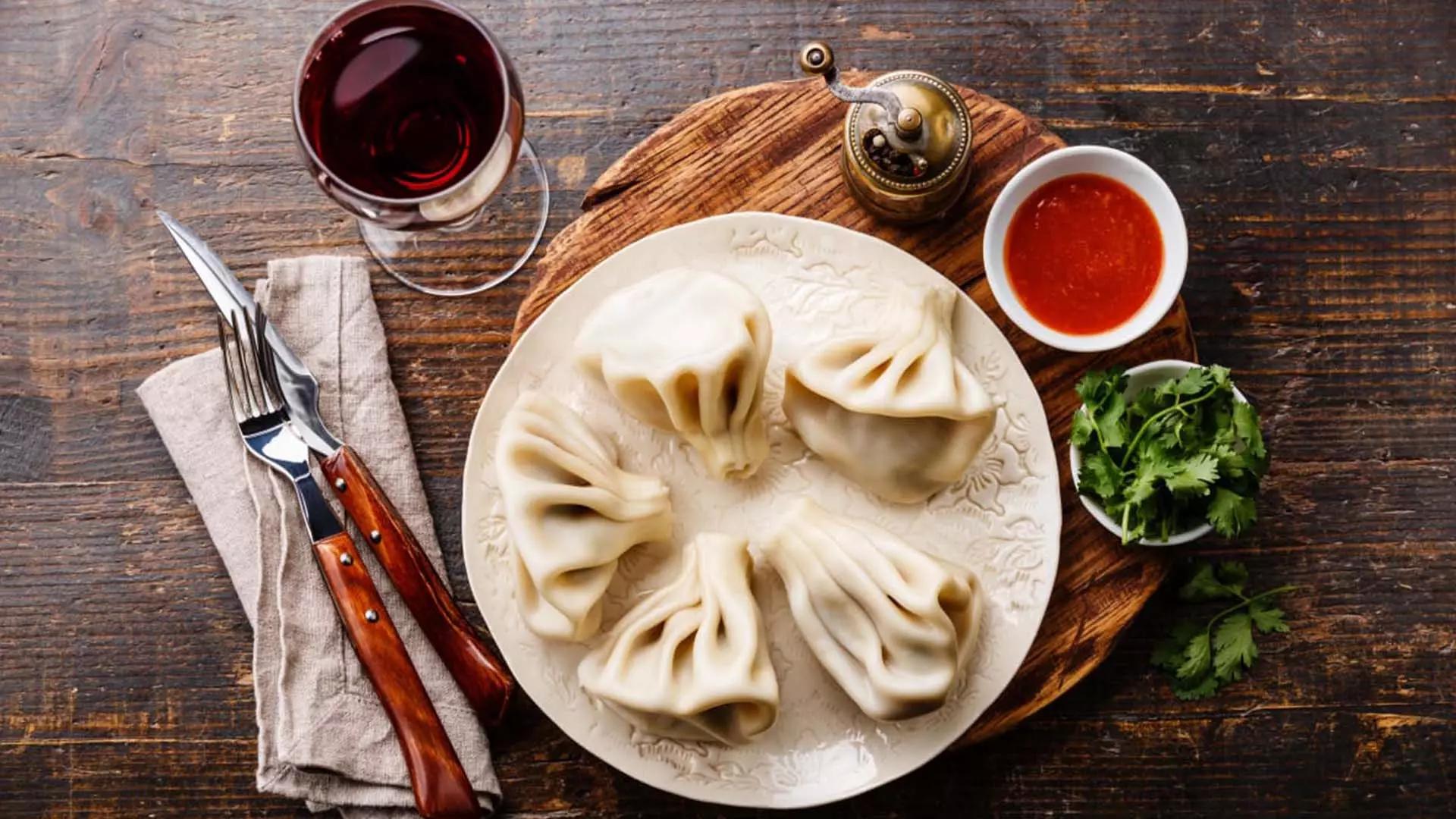 Georgian dumplings Khinkali with meat, tomato spicy sauce and wine